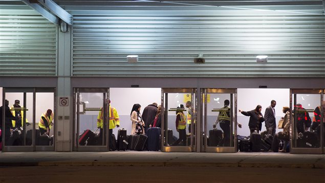 Les réfugiés syriens arrivent dans une aérogare aménagée pour eux à l'aéroport Pearson de Toronto.