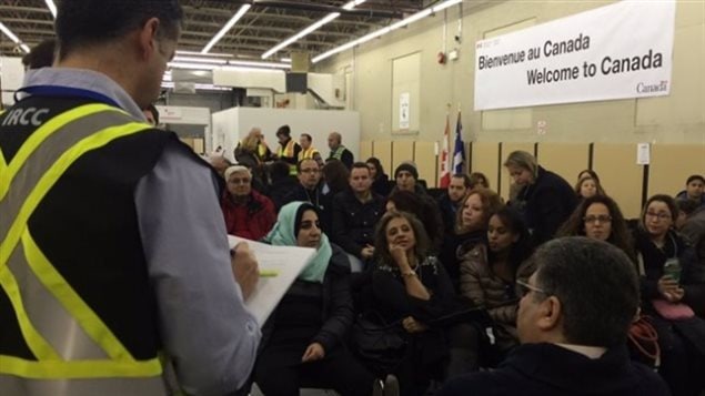 Newly-arrived refugees wait to be processed at Montreal’s airport on Dec. 12, 2015. Most are privately-sponsored.