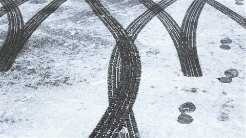 Traces de pneus sur une route enneigée.