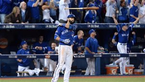Toronto Blue Jays Jose Bautista flips his bat after hitting a three-run homer during baseball division finals on October 14. The flip went viral as did the story of the team’s brilliant season. We Bautista standing at home plate watching his bat fly in front of him. He is dressed in his Jays dark blue jersey and white trousers as are his teammates in the dugout as they jump for joy watching Bautista's blast.