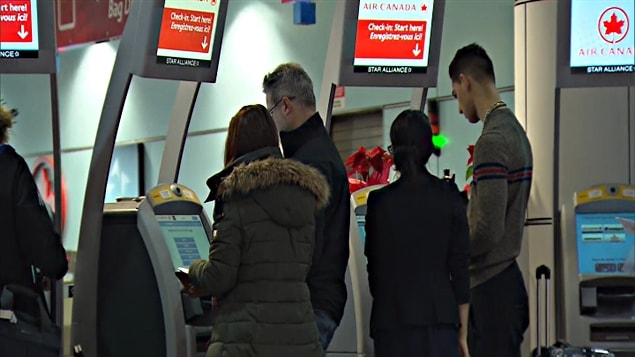 Des passagers s’enregistrent à l’aéroport Montréal-Trudeau.