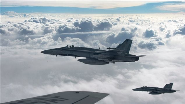  Royal Canadian Air Force CF-18 Hornets depart after refueling with a KC-135 Stratotanker assigned to the 340th Expeditionary Air Refueling Squadron, October 30, 2014, over Iraq. 