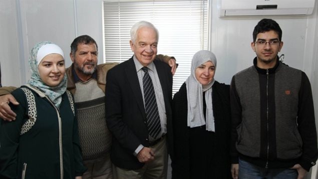 Le ministre canadien de l’immigration, John McCallum, au centre, pose pour une photo avec une famille syrienne à Amman, en Jordanie. (AP / Sam McNeil)