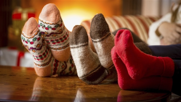 Trois personnes détendues au coin du feu à Noël Trois personnes détendues au coin du feu à Noël