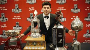 Canadiens goalie Carey Price had a season for the ages. We see Price dressed in a fancy tux standing behind four trophies stretched across a table in front of him at the NHL awards.