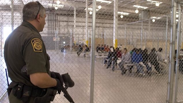 Un guardia fronterizo estadounidense vigila a indocumentados detenidos.
