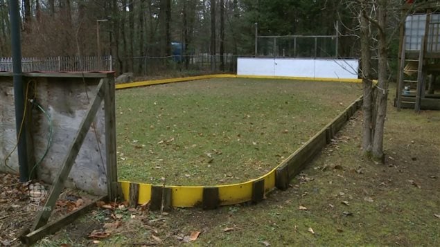 A backyard hockey rink, which should be covered with ice, and kids playing, is still green in St Lazare west of Montreal