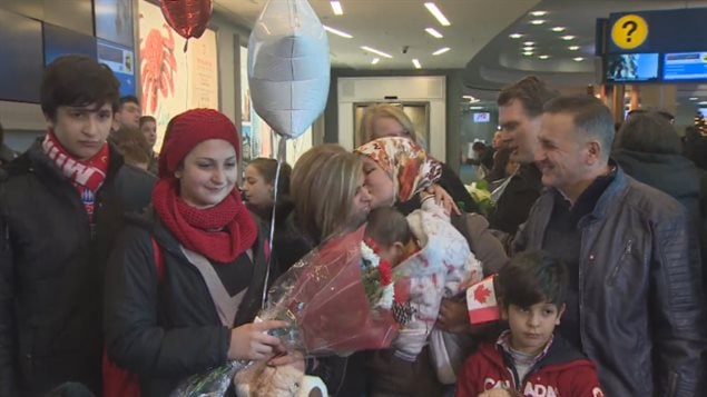  Tima Kurdi (centre) welcomes her brother Mohammad Kurdi, his wife and their five children, who she is sponsoring as refugees in B.C., at Vancouver International Airport on Monday. (CBC)