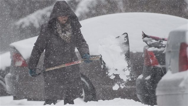  A woman shovels her driveway in the town of Hudson, west of Montreal, Tuesday, December 29, 2015 during the first major storm of winter. 