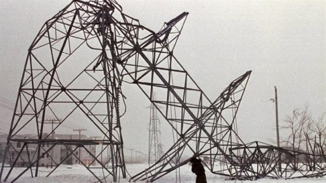 Jan. 15, 1998 -- A woman walks past a downed hydro pylon near St-Constant, Que. where hydro crews worked to reestablish power following the ice storm. 