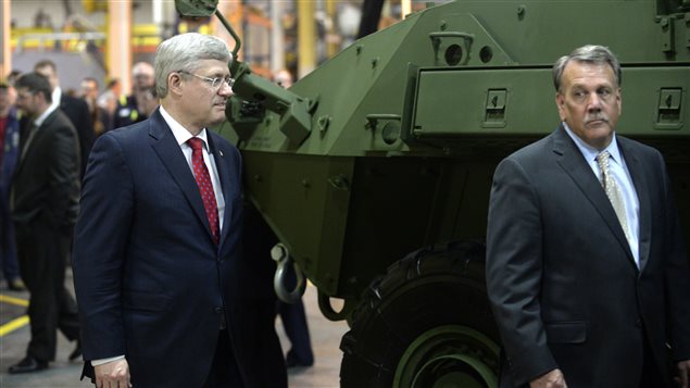  Former Prime Minister Stephen Harper walks past a Light Armoured Vehicle 6.0 during a photo opportunity at General Dynamics Land Systems in London, May 2, 2014.