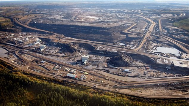 This file photo from Sept. 19, 2011, shows an aerial view of an oil sands mine facility near Fort McMurray, Alberta. Vast tracts of boreal forest gone from human development. Enormous mining, vast illegal logging in rainforests, forest clearing for cattle, dams, diversions, cities, roads, all changing the face of the Earth on an unprecedented scale