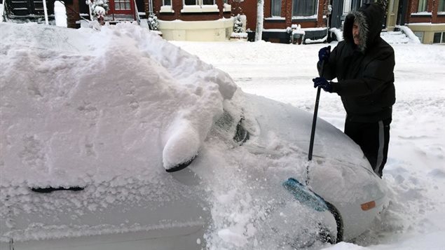 Dave Perry, de Saint-Jean en la provincia canadiense de Nuevo Brunswick, quitando la nieve de su vehículo con una escoba. 