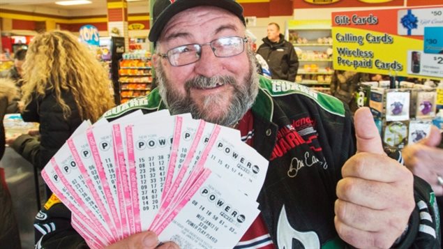 Robert Charbonneau, of St-Donat, Quebec, holds $1,000 worth of Powerball tickets for himself and his friends at a convenience store in the border town of Champlain, New York today. Those who don't want to wait in line are using websites like TheLotter.com, which buys tickets on their behalf, even though some lottery officials and Powerball organizers warn against using such unregulated services.