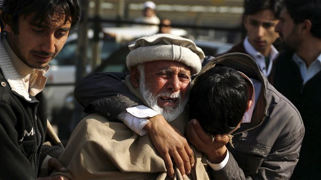 Personas lloran la muerte de familiares en el atentado de Peshawar.