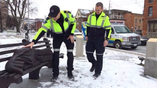 Paramedics approach a figure on a bench in a photo from the Hamilton Paramedics Twitter page. The statue in Hamilton is getting a lot of attention from paramedics as a recent blast of wintry weather has resulted in calls about a homeless person sleeping on a bench. The realistic looking blanket covered figure and bench are in fact made of bronze. The sculpture by an Ontario artist is called *homeless Jesus*