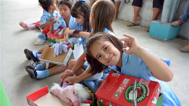  Children unwrap gifts at an Operation Christmas Child Canadian shoebox distribution at a school in Costa Rica. Photo: Frank King/Samaritans Purse Canada