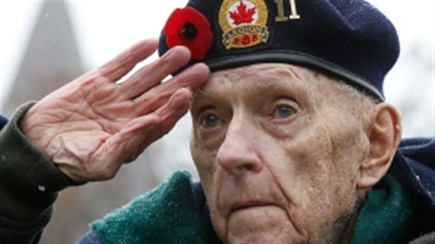 Second World War veteran Bruce Bullock gives the open hand salute during the Remembrance Day ceremony at the National War Memorial in Ottawa on Nov. 11, 2013. The open palm salute was used in Canada until unification of the army, navy and air forces in Canada in 1968, when the *American* plam-down salute became the standard.