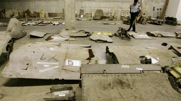 A member of the RCMP looks over wreckage of Air India Flight 182 as it sits on display in an undisclosed location in Vancouver, British Columbia June 15, 2004. The plane was exploded high over Irish airspace and many pieces were recovered from the ocean floor