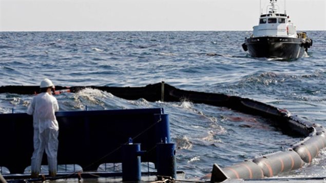 A worker looks over an oil boom in April 2010 near the Deepwater Horizon oil rig leak in the Gulf of Mexico. Deploying booms for a large Arctic offshore oil spill would be nearly impossible because of icebecause Arctic ice, lack of daylight, winds and temperatures make it extremely difficult to contain, burn off or disperse spilled oil, accroding to the WWF in a report to Canada’s National Energy Board in 2011