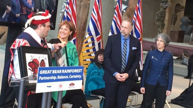 Dallas Smith of the Nanwakolas Tribal Council presents B.C. Premier Christy Clark with a gift at the announcement of the Great Bear Rainforest agreement.