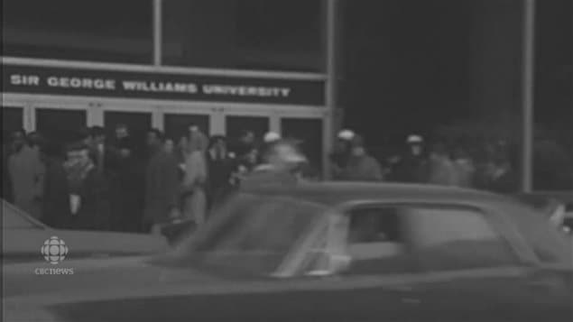 Police in white helmets and crowds milling around the occupied Sir George Williams University in 1969. in downtown Montreal.