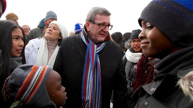 Le maire de la ville de Québec, Régis Labeaume, salut de jeunes immigrants qui découvrent le Carnaval de Québec