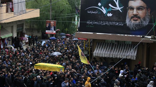  Relatives and comrades carry the coffin of Hezbollah member Ali Ahmad Sabra, who was killed on Friday during an offensive by Syrian troops and Hezbollah fighters in Syria, during his funeral procession in Jibchit, southern Lebanon, Saturday, Feb. 6, 2016. A billboard shows Hezbollah leader Sheik Hassan Nasrallah with Arabic that reads, *Al Hussein the secret of our victories.*