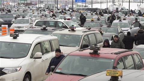 Plusieurs centaines de chauffeurs de taxi bloquent la circulation à l’aéroport Trudeau de Montréal. le 10 février, pour protester contre Uber.