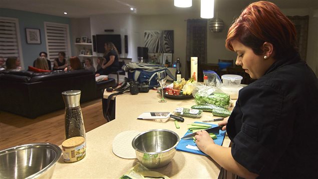 Carolane Lauzière s'affaire à préparer une repas à domicile tandis que les convives discutent au salon. Carolane Lauzière s'affaire à préparer une repas à domicile tandis que les convives discutent au salon.