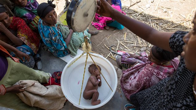  A baby is weighed on a scale in Ethiopia. Two seasons of failed rains mean that nearly six million children across Ethiopia currently require food assistance.