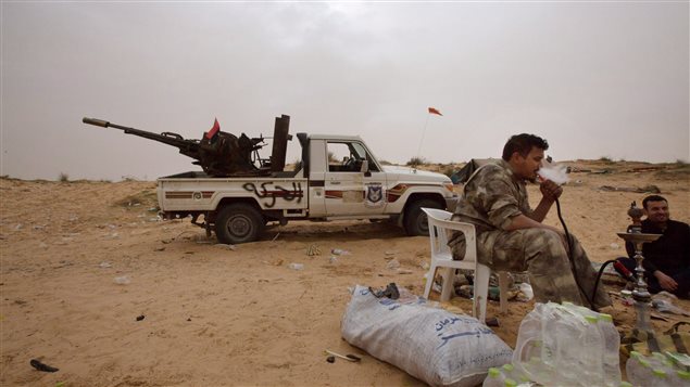  In this Saturday, Feb. 21, 2015 photo, Libyan soldiers take a break from fighting with militants on the frontline in Al Ajaylat, 120 kilometers west of Tripoli, Libya.