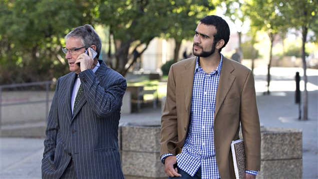 Former Guantanamo Bay prisoner Omar Khadr (right) and his lawyer Dennis Edney wait for their ride in Edmonton after a hearing on bail conditions on September 11, 2015.