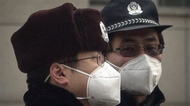  Chinese policemen wear pollution masks as they stand guard near the Beijing No. 2 People’s Intermediate Court where human rights lawyer Pu Zhiqiang was sentenced in Beijing, China, Tuesday, Dec. 22, 2015.