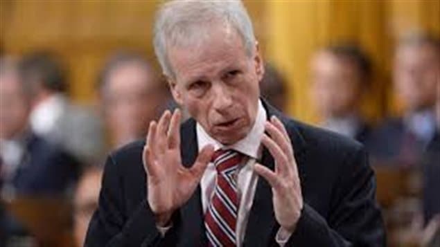 Canadian Foreign Affairs Minister Stephane Dion is seen gesturing with both hands fairly tight together in the House of Commons. He has short grey hair and wears a regimental tie and dark sports jacket.