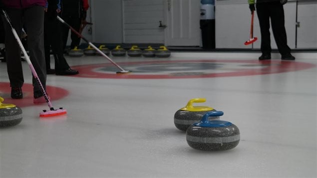 Des joueurs de curling et leurs pierres Des joueurs de curling et leurs pierres