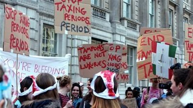Mujeres en Inglaterra exigiendo que se retiren los impuestos a la venta de tampones.