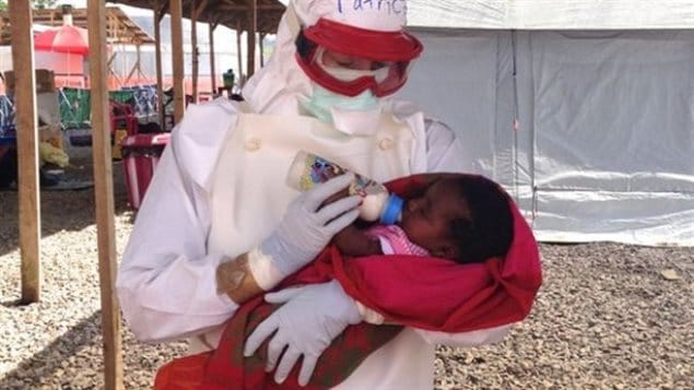 Patrice Gordon a nurse practitioner from Canada’s west coast province of British Columbia, shown here nursing a biaby with Ebola in Sierra Leone in 2014. Upon her return to Canada she exhibited tow symptoms, but later tested negative for the disease.