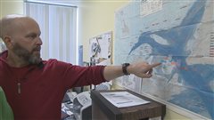 Gilles Thériault, directeur de l'Association des chasseurs de phoques des Îles-de-la-Madeleine pointe une carte.