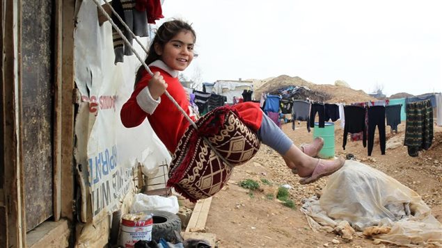 A girl plays on a swing in the Al Faida informal tented settlement for Syrian refugees, in the Bekaa Valley, Lebanon.