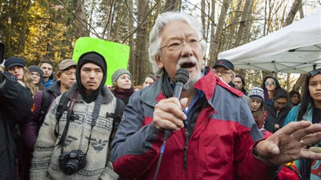 Environmental activist David Suzuki speaks to the crowd on Burnaby Mountain on Nov. 23, 2014, as his grandson Tamo Campos, left, looks on