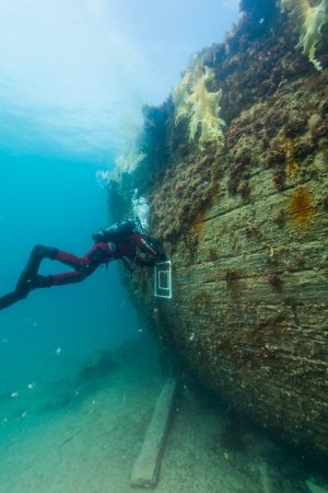 Marc-André Bernier, Parks Canada’s manager of underwater archelogy, sets a marine biology sampling quadrat on the port side hull of HMS Erebus. 