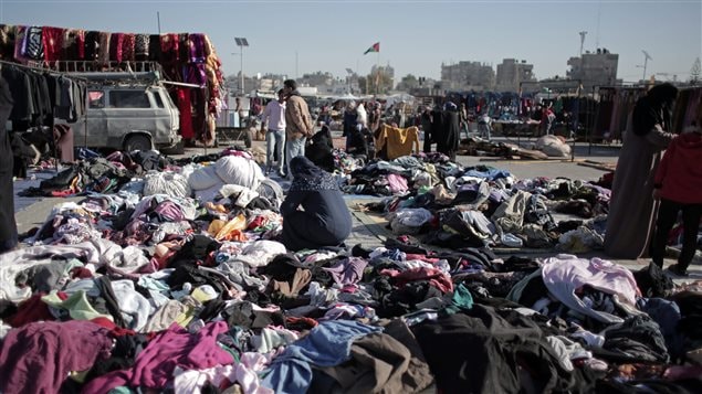 On Feb. 15, 2016 a Palestinian woman scours a used clothing market in Gaza. Demand for clothing is said to be an indicator of poverty and unemployment levels.