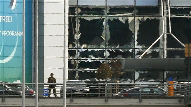  A soldier stands near broken windows after explosions at Zaventem airport near Brussels, Belgium, March 22, 2016.