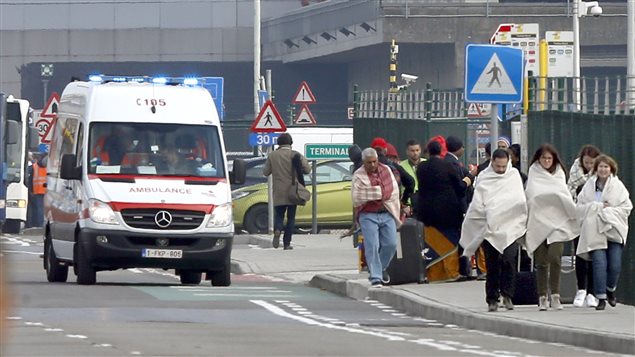  People wrapped in blankets leave the scene of explosions at Zaventem airport near Brussels, Belgium, March 22, 2016.