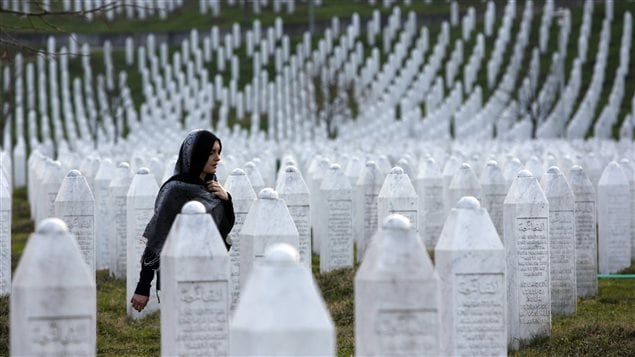  In this photo taken on Sunday, March 20, 2016, a Bosnian woman walks among gravestones at Memorial Centre Potocari near Srebrenica, Bosnia and Herzegovina. 