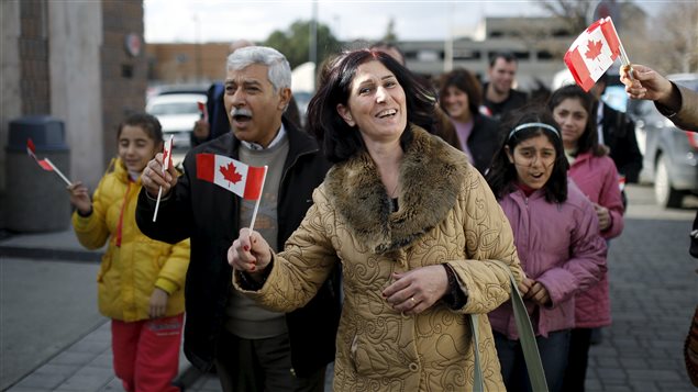  Syrian refugees Elo Manushian (C) arrives with her husband Hagop (2nd L) at the Armenian Community Centre of Toronto in Toronto, December 11, 2015.