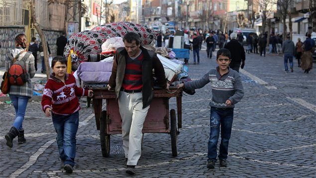  In this photo taken on Wednesday, Feb. 3, 2016, a family leave the Sur district in Diyarbakir, Turkey. The family are among tens of thousands displaced by fighting raging between Turkish security forces and militants in the southeast after a peace process collapsed in the summer.