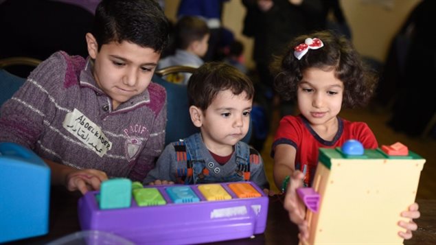 Abdelkader, 10, Morhaf, 20 meses, y Khadija, 5, juegan en un centro para niños refugiados sirios organizado por el Centro de salud comunitaria de Ottawa el 9 de marzo 