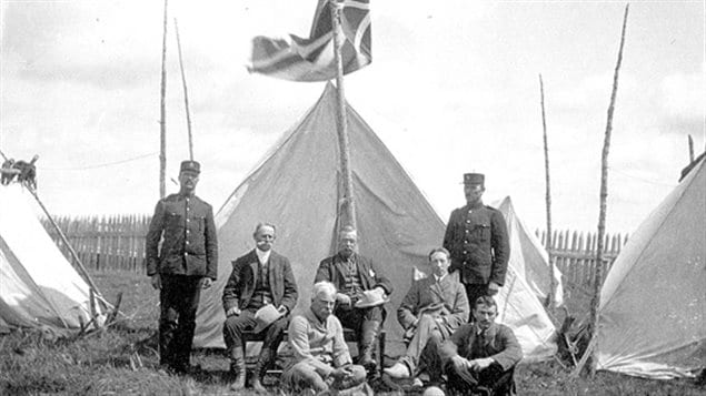 The James Bay Treaty signing party at Fort Albany in 1905. Standing: Joseph L. Vanasse (L), James Parkinson (R) of NWMP. Seated: Commissioners Samuel Stewart (L), Daniel George MacMartin, Duncan Campbell Scott (R)